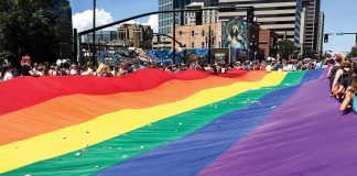 Utah Pride Parade participants with rainbow flag.