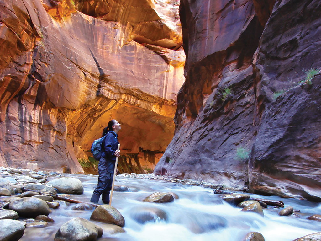 Woman hiking through Zion Narrows_SLMSO24_AdobeStock_1450755